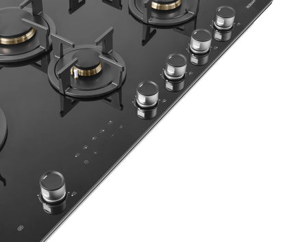 Black gas stove with glass cooktop on a white background